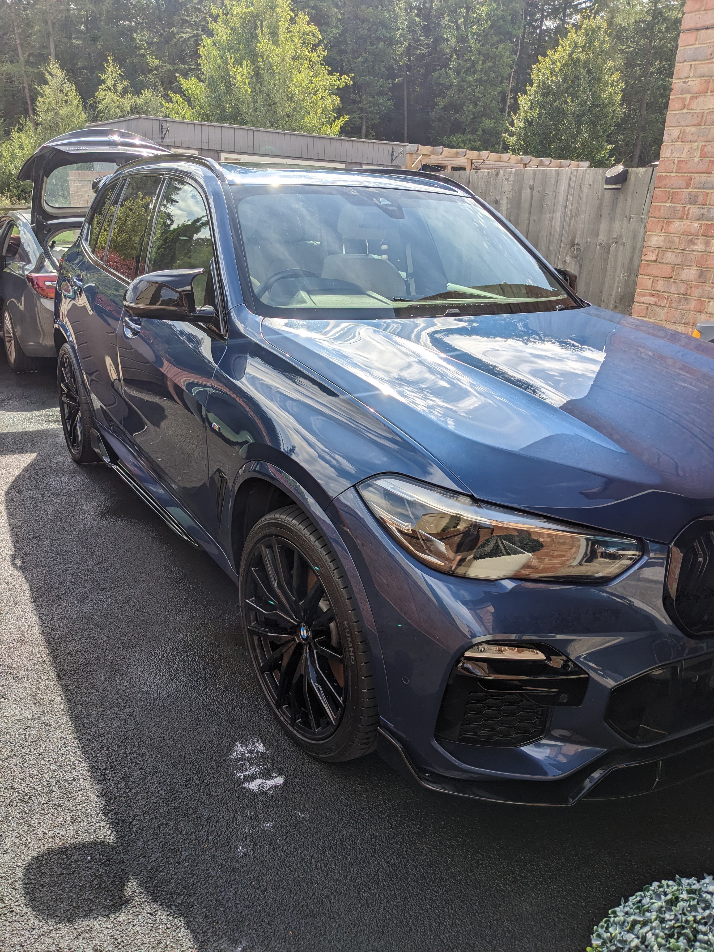 Freshly detailed blue BMW reflecting the sky